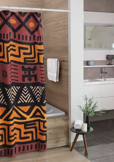 a bathroom with a bathtub, sink and shower curtain that has an abstract design on it