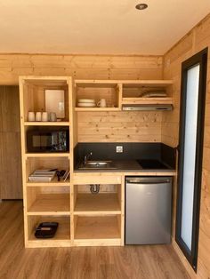 a small kitchen with wooden walls and flooring