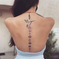 the back of a woman's neck with tattoos on her upper and lower back