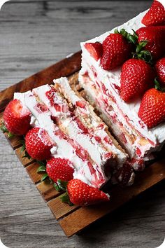 a large piece of cake with strawberries on the side and one slice cut out