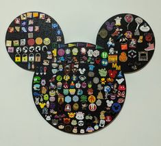 a mickey mouse head made out of hundreds of stickers on a white wall with black background