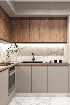 a modern kitchen with marble counter tops and wooden cabinetry, along with white walls