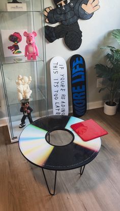 there is a small table with a cd on it in front of some stuffed animals