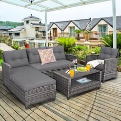 an outdoor living area with grey wicker couches and coffee table on a wooden deck