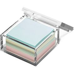 a stack of post - it notes in a clear box on a white background with clippings