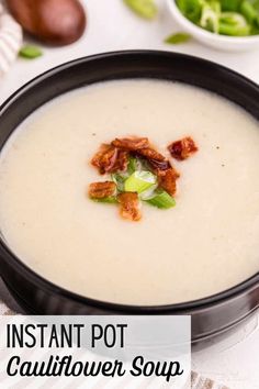 a bowl of instant pot cauliflower soup with bacon and green onions in it