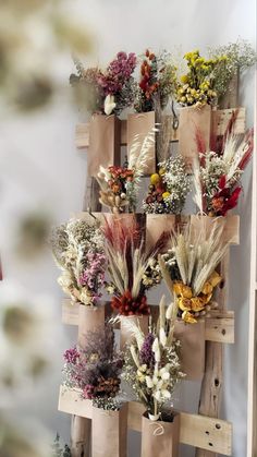 a bunch of dried flowers are arranged on a wooden pallet as if it were made out of wood planks