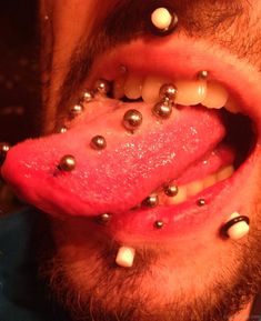 a man with piercings on his tongue and nose