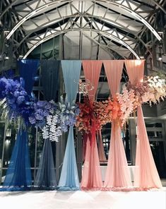 several different colored drapes and flowers in front of a building