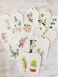 six tags with flowers on them sitting on a table