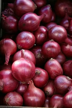 red onions are piled up in a box