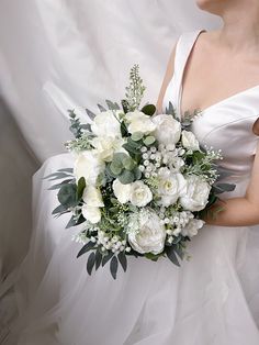 a bridal holding a bouquet of white flowers