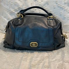 Large Campbell Turnlock Satchel In A Beautiful Textured Pearlized Navy Blue Leather That Almost Looks Black, Very Good Condition! The Brass Hardware Does Show Minimal Signs Of Wear. The Handles Also Had The Leather Piping Come Off In Certain Spots That I Tried To Show In The Pictures But It Is Almost Undetectable In Person. There Is Also A Slight Mark On The Top Of The Bag That I Showed In The Pictures That I Believe Is Just A Slight Defect In The Leather But I Wanted To Disclose It. Again It’s Hardly Recognizable. The Lining Of The Bag Is In Almost Perfect Condition! I Have The Two Charms/Tags That The Bag Came With Although I Do Not Have The Piece That Attaches Them To The Bag But That I Luxury Coach Satchel With Metal Hardware, Elegant Coach Satchel With Metal Hardware, Designer Coach Satchel With Branded Hardware, Coach Black Satchel With Handle Drop, Blue Leather Coach Satchel, Coach Satchel With Silver-tone Hardware For Travel, Coach Satchel With Silver-tone Hardware, Black Coach Satchel With Silver-tone Hardware, Almost Perfect