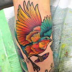 a colorful bird tattoo on the left arm and leg, with an arrow in the middle