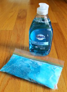 a bottle of dish soap sitting on top of a wooden table next to a bag