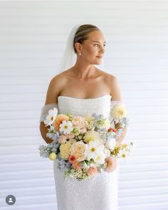 a woman in a wedding dress holding a bouquet of flowers