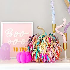 a white mantle topped with a pink vase filled with confetti