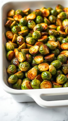 brussel sprouts in a white casserole dish on a marble counter