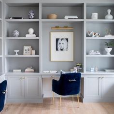 two blue chairs sitting in front of a white bookcase