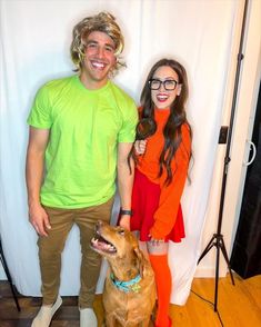 a man and woman posing with a dog in front of a white backdrop for a photo shoot