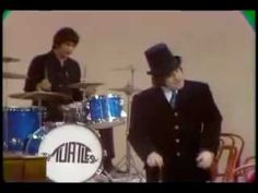 two men in suits and hats are playing drums