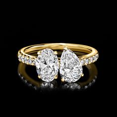 two pear shaped diamond engagement rings in yellow gold