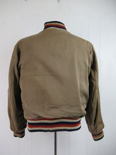 "Vintage 1940s school stadium jacket. Made of thick blue and red wool, reverses to khaki cotton twill. Has red, white and blue banded waist, collar and cuffs, a snap front and two waist pockets on each side. Large basketball patch reads: GORDON LOCAL 12 47. Label reads: BUTWIN. About a size medium to large. Actual measurements are: 44\" at the chest 38\" at the unstretched waist 19\" shoulder seam to shoulder seam 23\" shoulder seam to cuff 25\" overall length In good condition. Khaki side has s Retro Cotton Sports Outerwear, Retro Cotton Outerwear For Sports, Retro Cotton Varsity Jacket For Sports, Retro Cotton Varsity Jacket For College, Retro Cotton Track Jacket For Winter, Vintage Fall Outerwear For Sports Events, Vintage Varsity Jacket For Fall Sports Events, Vintage Varsity Jacket With Ribbed Cuffs For Winter, Vintage Winter Track Jacket For Sports Events