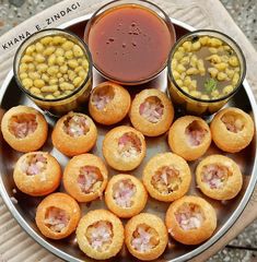 some food is sitting on a plate with sauces and corn in the bowl next to it