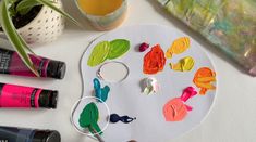 an artist's palette with paint, brushes and other art supplies on a table