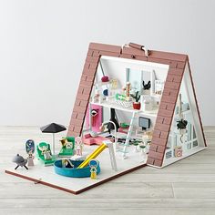 a doll house with furniture and accessories in the shape of an open window, on top of a wooden floor