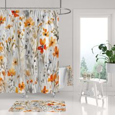 an orange and white floral shower curtain in a room with a potted plant on the floor