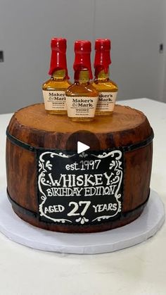 a birthday cake with three bottles of whiskey on top