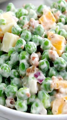 a white bowl filled with peas and fruit salad