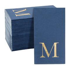 a stack of blue napkins with gold m on the front and back, stacked together