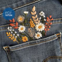 the back pocket of a pair of jeans with embroidered flowers