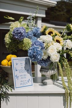 blue and white flowers are in a vase on a table next to a menu card