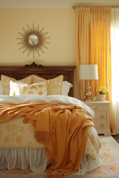 a bedroom with yellow drapes and orange curtains on the window sill, white bedding, and a large sunburst