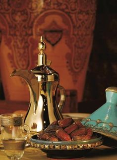 a table topped with plates and cups filled with food next to a teapot on top of a table