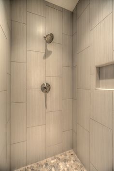 there is a shower in the bathroom with white tile on the walls and flooring