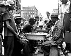 an old black and white photo of men playing chess on the street in new york city