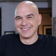 a man with bald hair smiling at the camera