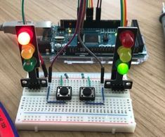 an electronic device with two traffic lights on top of it and wires attached to the board