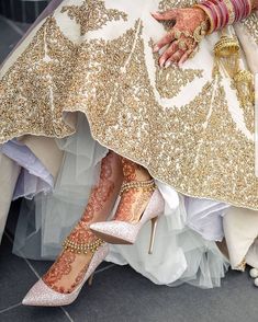 a bride's feet with gold and white shoes