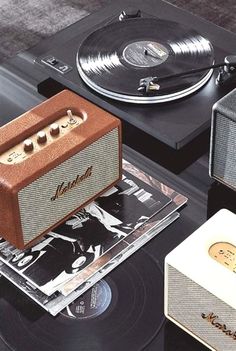 an old record player sitting on top of a table next to two other records and speakers