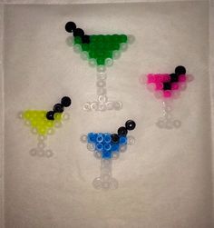 four different colored plastic beads in the shape of glasses