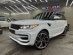 a white range rover parked in a showroom