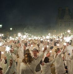 a large group of people holding sparklers in their hands