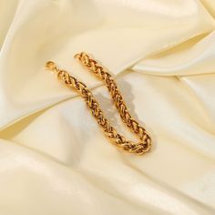 Crafted with an intricate wheat chain design, this bracelet combines the durability of 18k gold plating with a refined aesthetic. Its elegant, intertwined links offer a sophisticated touch to both casual and formal ensembles. Classic Gold Bracelets With Rope Chain, Gold Wheat Chain Bracelet As Gift, Gold Wheat Chain Bracelet Gift, Classic Rope Chain Bracelet, Elegant Gold Bracelet With Rope Chain, Timeless Gold Chunky Chain Bracelet, Timeless Gold Bracelet With Chunky Chain, Classic Gold Bracelet With Wheat Chain, Formal Gold Bracelet With Wheat Chain