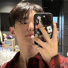 a young man taking a selfie with his cell phone in front of him and looking at the camera