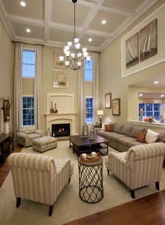 a living room with couches, chairs and a fire place in the center area